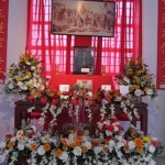 The Ancestor Veneration Altar with picture of Chinese martyrs above and an urn for incense sticks